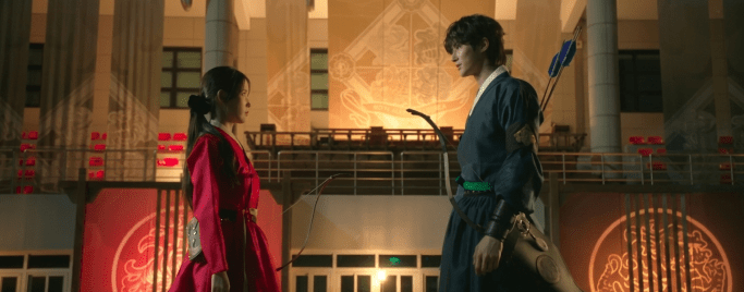 IU in a crimson hanbok and Byeon Woo-seok in a dark blue hanbok facing each other in the K-drama Perfect Crown